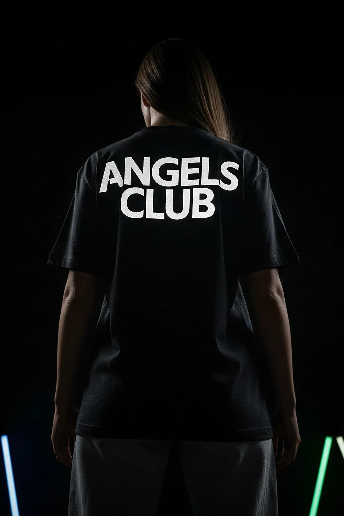 ANGELS CLUB büyük ön baskılı reflektörlü siyah oversize tişört kadın model üzerinde parlayan yazı