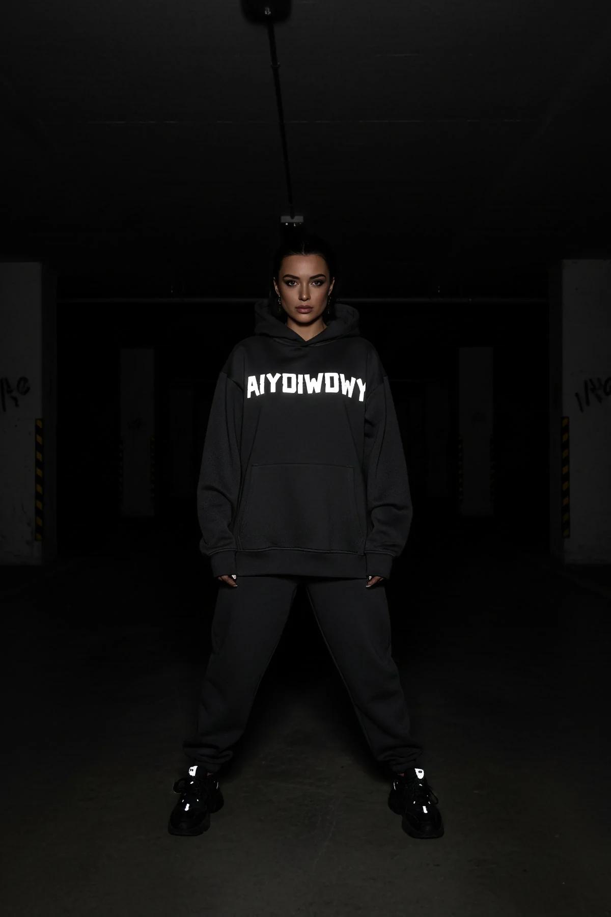 AIYGIWGWY reflektörlü siyah sweatshirt model oturmuş ön baskı yakın