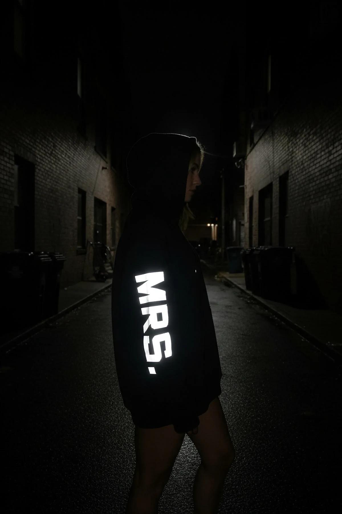 MR. reflektörlü sırt baskılı siyah kapüşonlu oversize sweatshirt, erkek model sırttan gece çekimi
