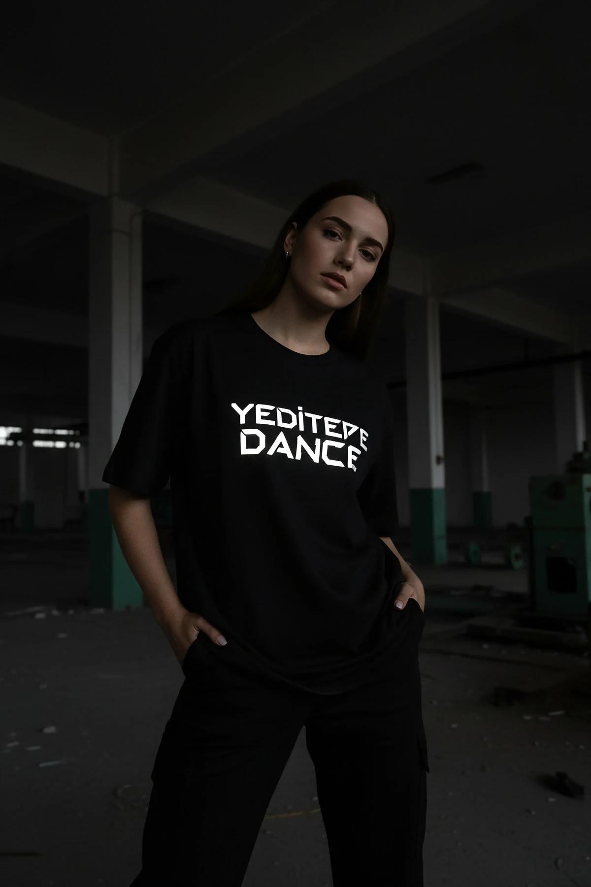 Tişört üzerindeki minimalist çizgi detaylarının gün ışığındaki mat gümüş renk görünümü