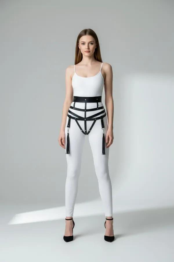 black faux leather caged waist harness with silver O-rings and tassel drops worn over white bodysuit