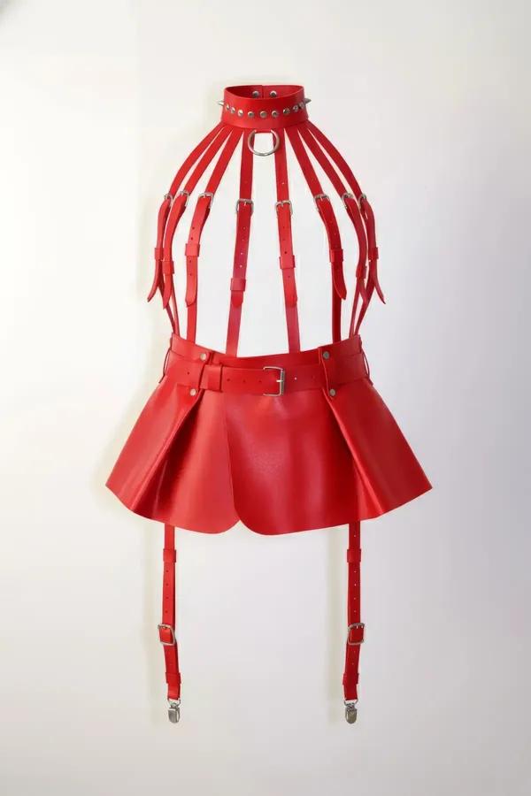 red faux leather caged body harness skirt set with studded choker, silver D-ring, pleated mini skirt, and four garter clips