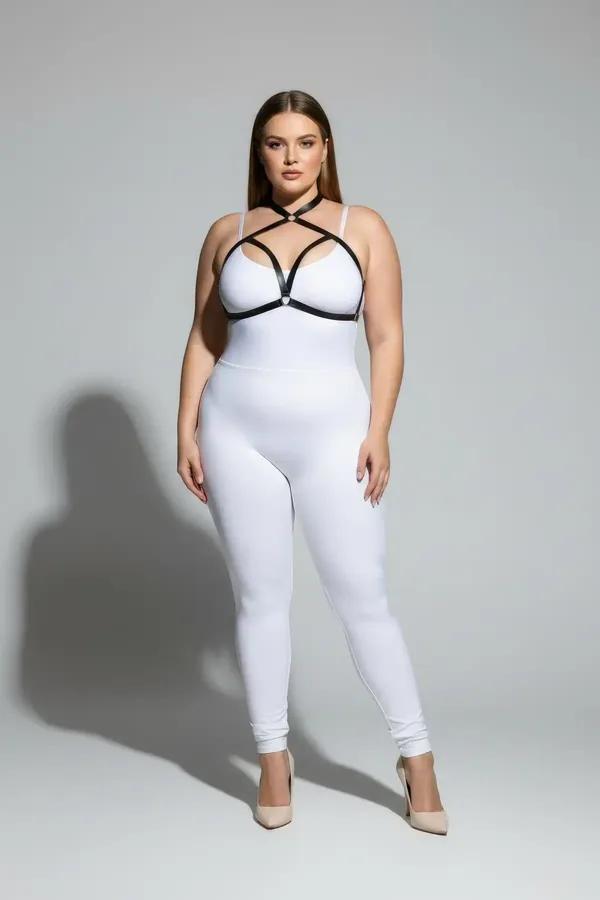 black faux leather strappy chest harness with silver O-ring geometric X-strap cage worn over white bodysuit plus size model