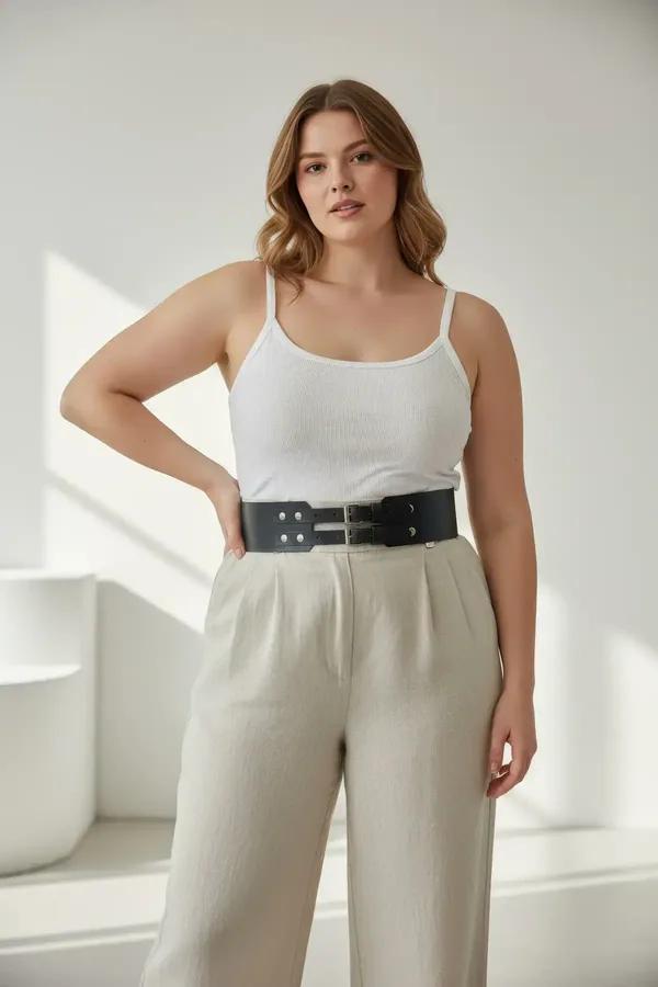 black faux leather waspie waist belt with double silver buckles and stud details worn over white tank top