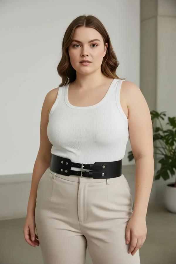 black faux leather waspie waist belt with double silver buckles and stud details worn over white tank top