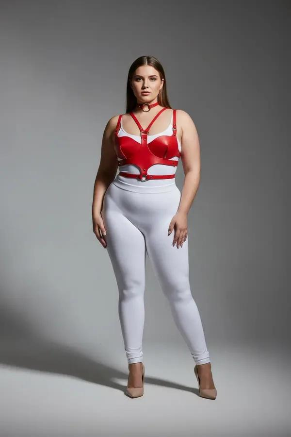 red faux leather chest harness with molded cups and integrated silver O-ring choker worn by plus-size model