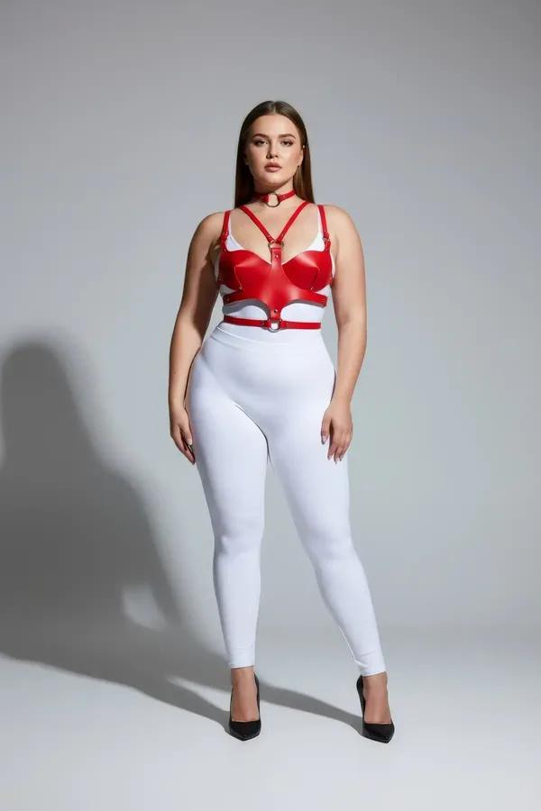 red faux leather chest harness with molded cups and integrated silver O-ring choker worn by plus-size model