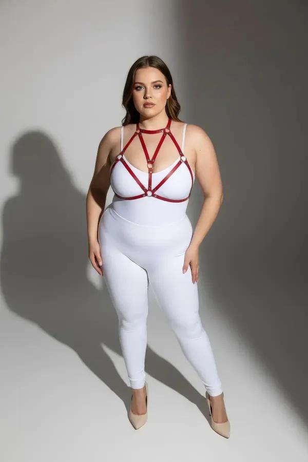 red faux leather strappy body harness with gold O-ring connectors worn as chest harness over white bodysuit