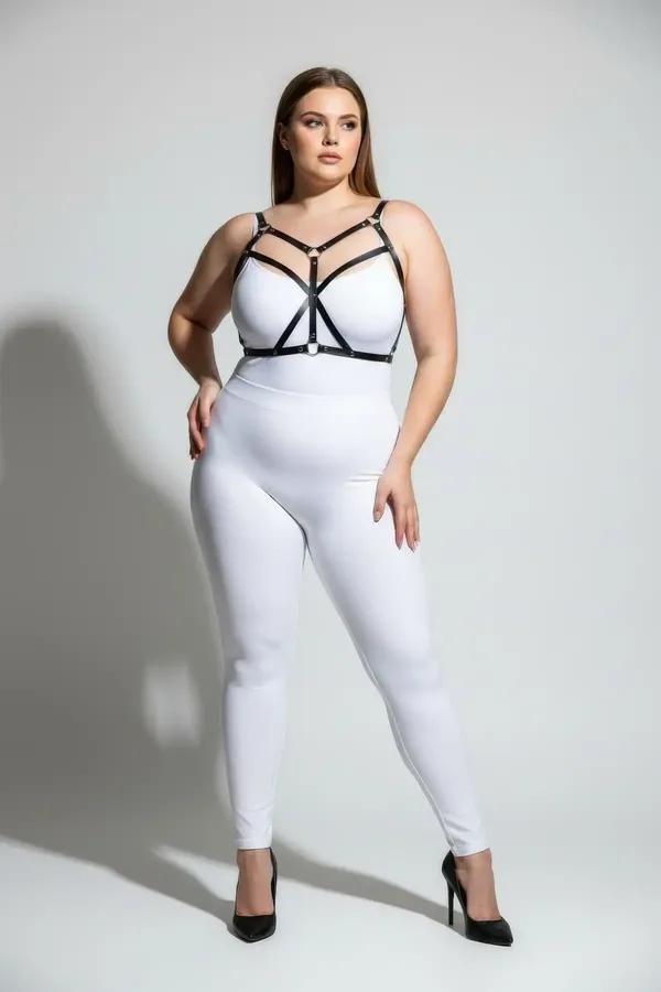 black strappy faux leather body harness with silver O-ring detail worn over white bodysuit plus size model