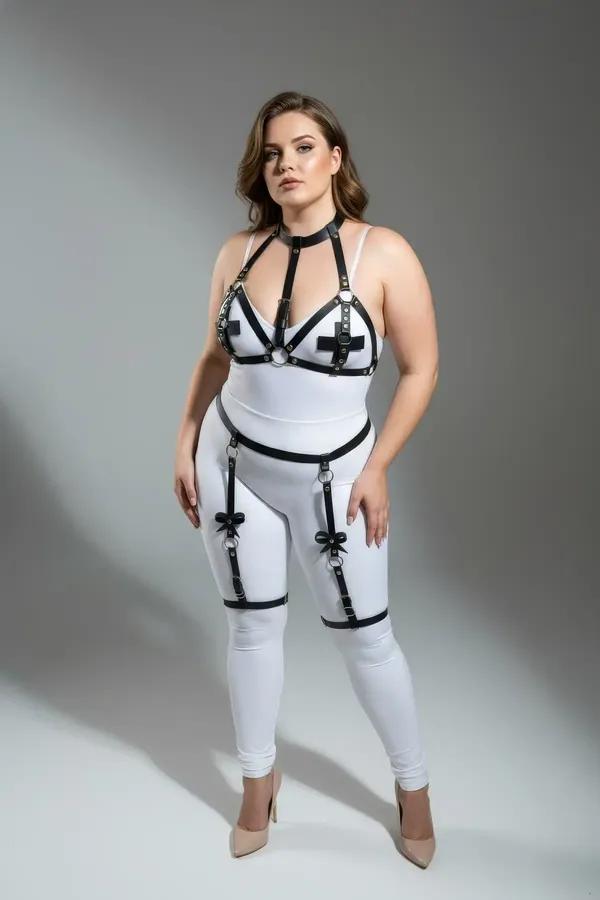 black vegan leather strappy garter body harness with silver O-rings and cross accents worn over white bodysuit