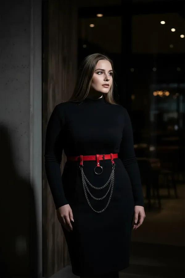 red faux leather waist harness belt with black O-ring and triple draped gunmetal chains worn over black dress