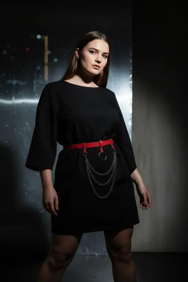 red faux leather waist harness belt with black O-ring and triple draped gunmetal chains worn over black dress