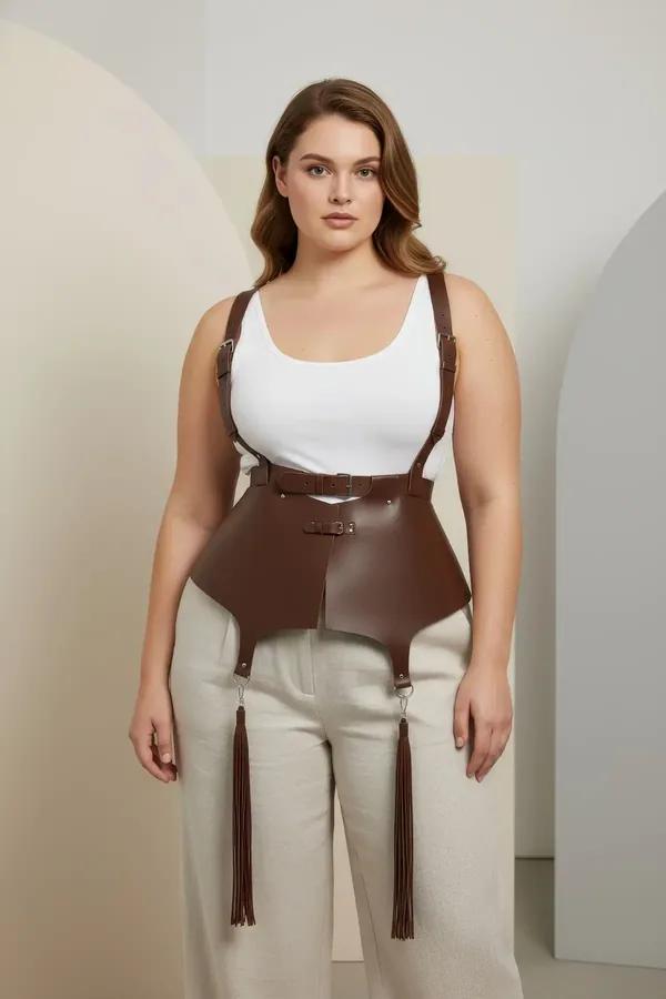 brown faux leather corset harness with gold buckles adjustable shoulder straps and tassel drops worn over white top