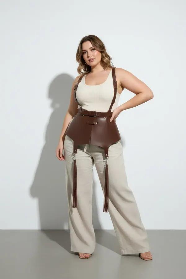 brown faux leather corset harness with gold buckles adjustable shoulder straps and tassel drops worn over white top