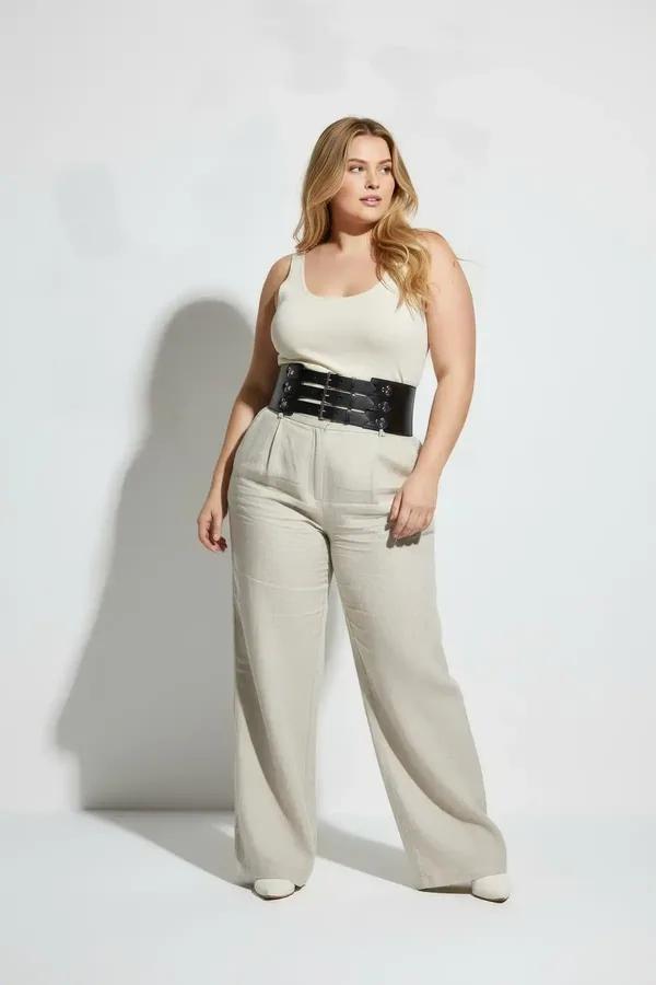 black faux leather wide waist harness belt with three silver buckle straps worn over white tank top
