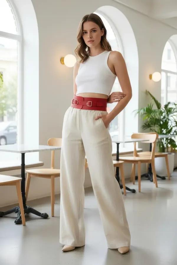 red faux leather wide waist cincher harness with double silver D-ring buckles worn over white crop top