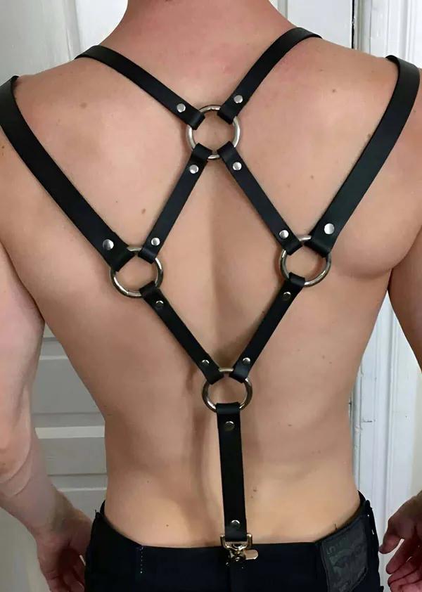 Siyah suni deri erkek harness sırt görünümü — X çapraz bant, 5 gümüş O-halka ve altın ıstakoz toka