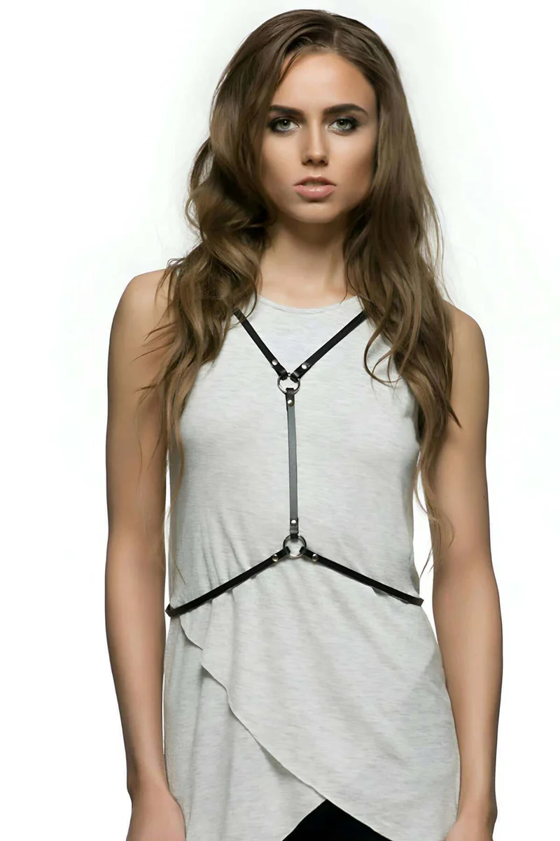 Close-up of the central O-ring and snap hook hardware on black faux leather harness