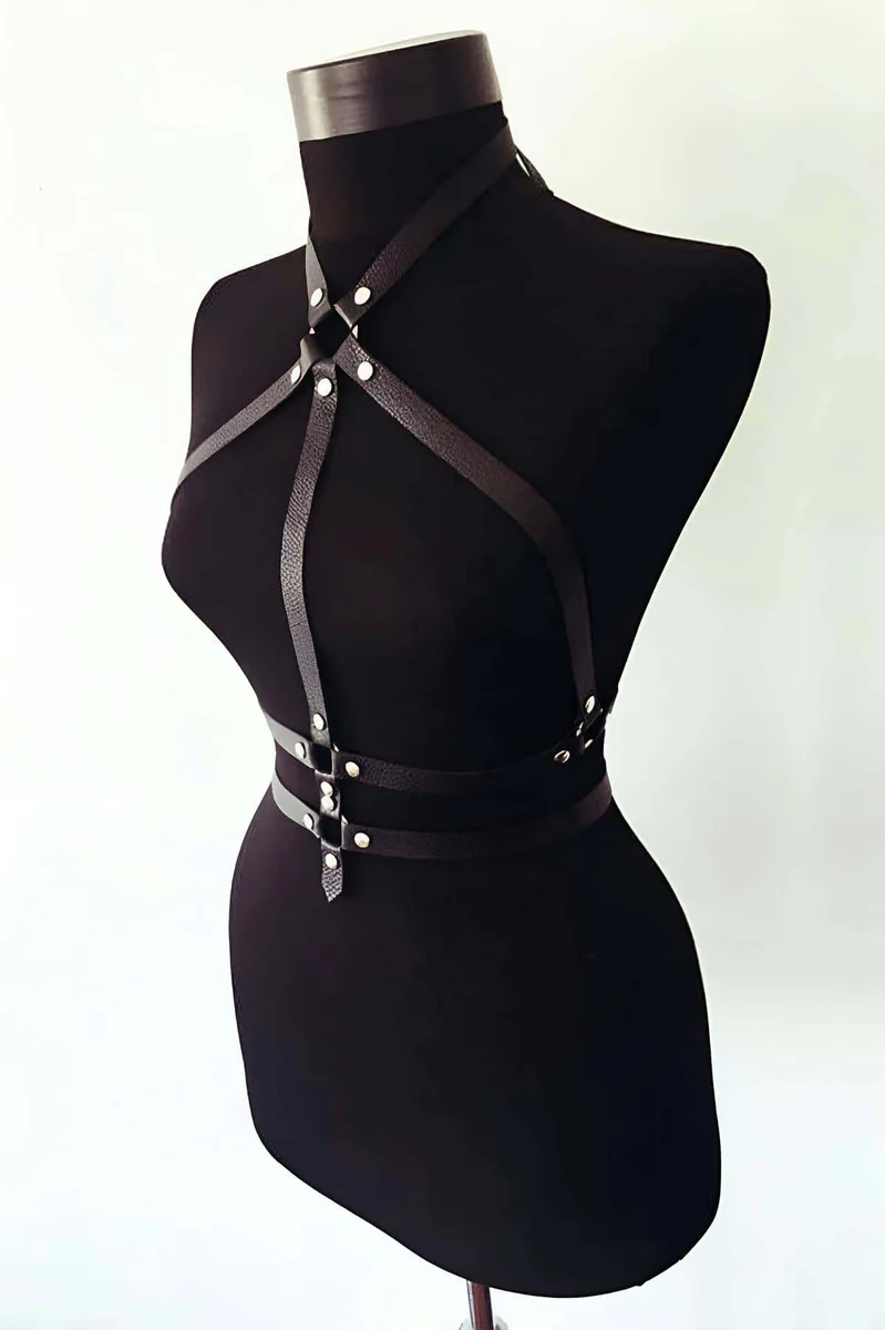 Close-up of black faux leather strappy body harness O-ring detail