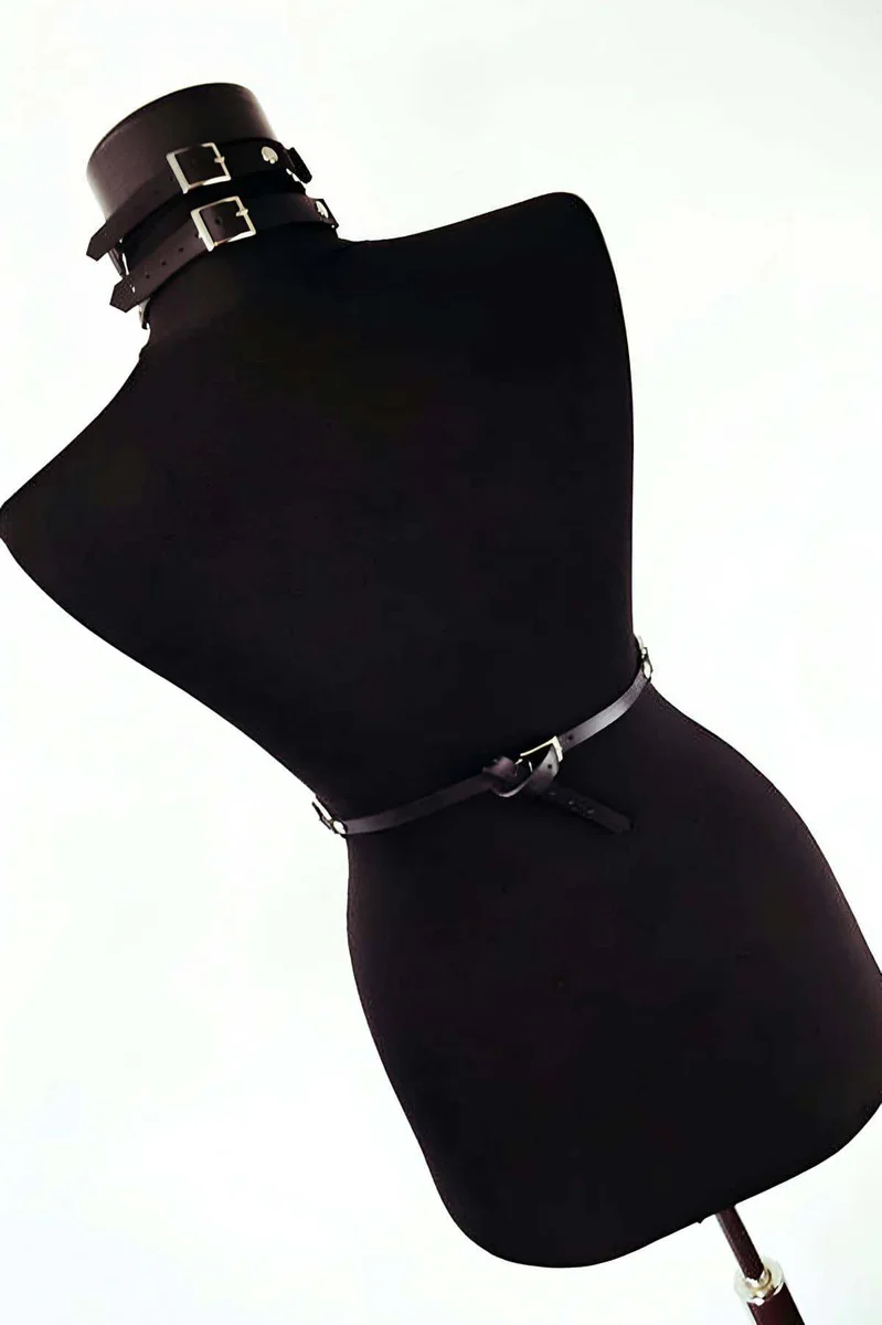 Black faux leather waist belt with central O-ring and buckle closure