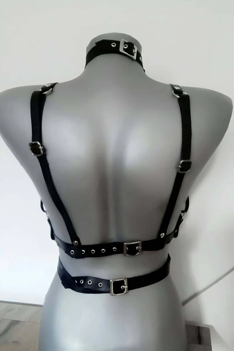 Adjustable neck strap detail on black faux leather chest harness with buckle accents