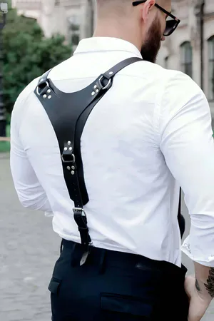 Black faux leather Y-back body harness with O-ring, worn over a white shirt