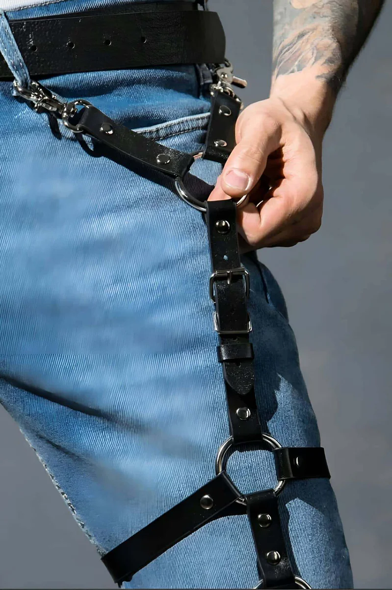 Close-up of black faux leather thigh harness O-ring detail and adjustable straps