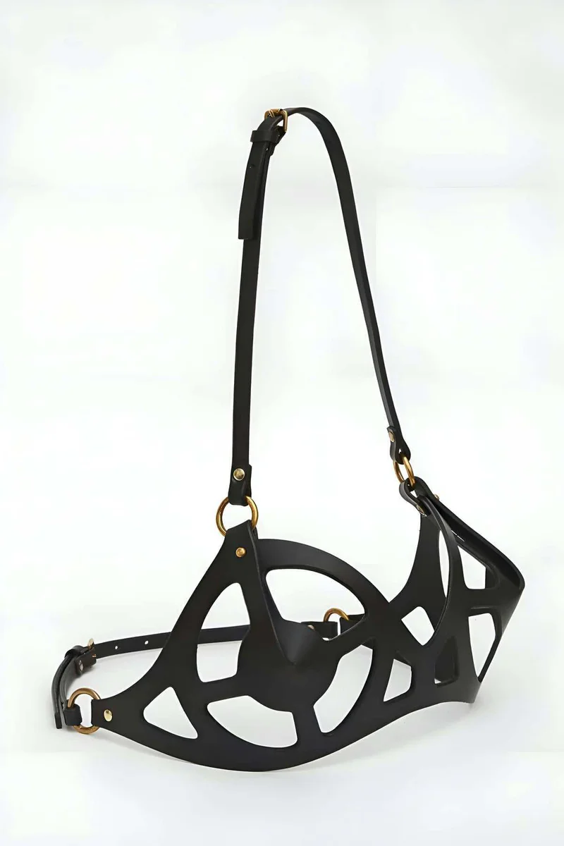 Close-up of silver O-ring hardware on black faux leather harness bra strap