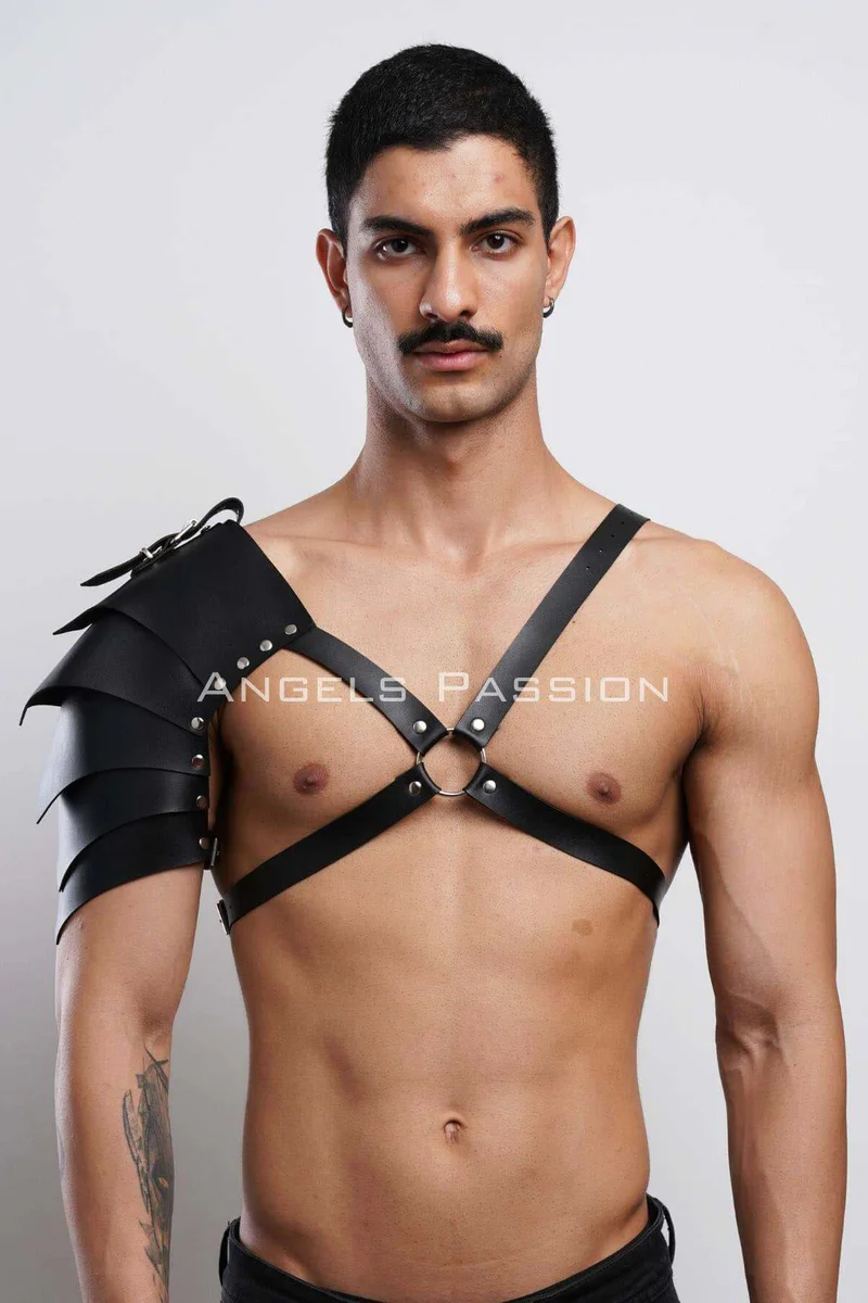 Black layered faux leather shoulder armor detail close-up with chest straps