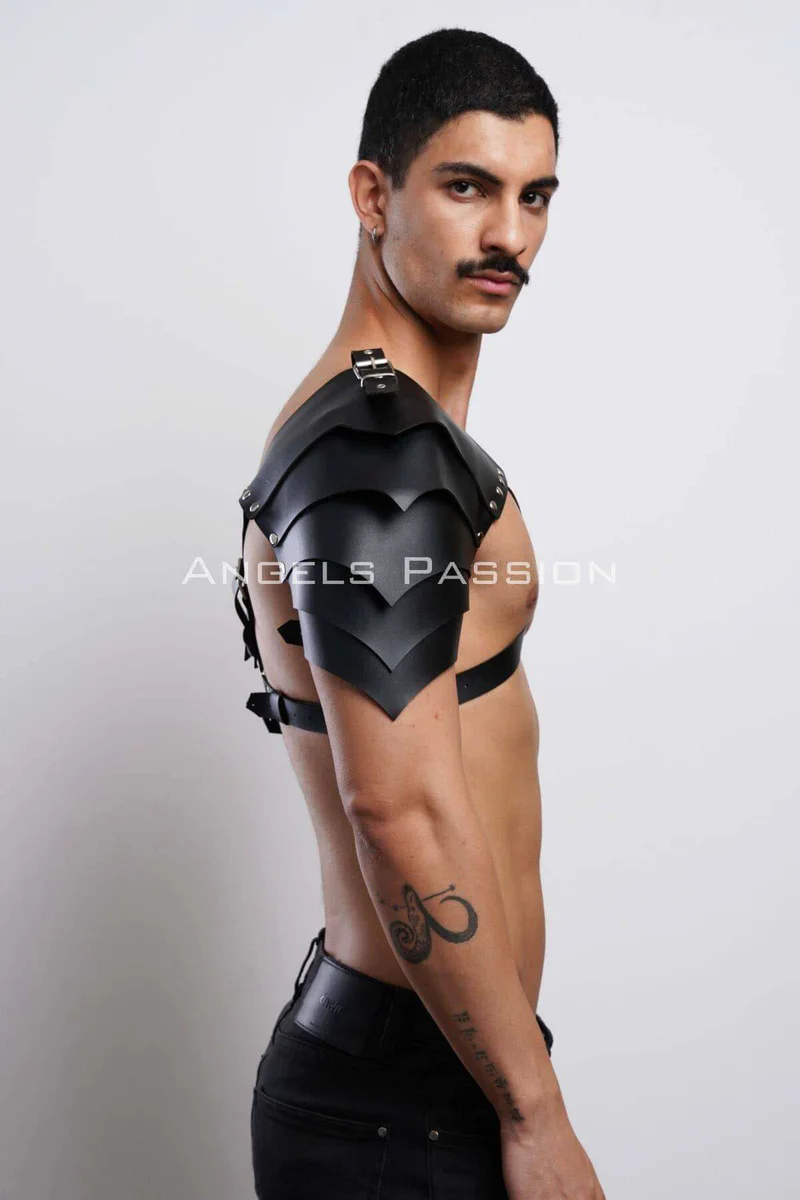 Black faux leather shoulder harness styled with a black top showing scaled shoulder detail