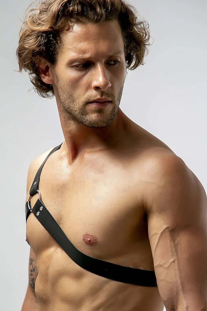 Black faux leather chest harness with asymmetrical strap configuration close-up