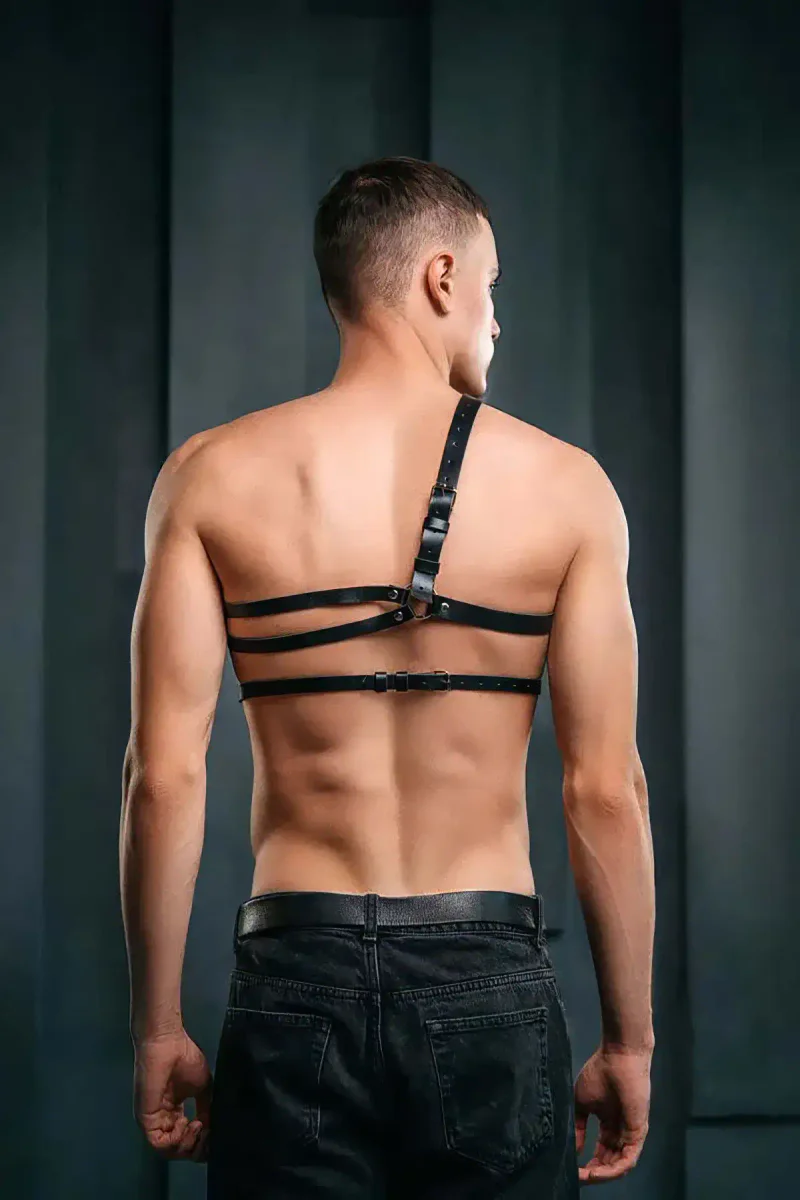 Model wearing a black vegan leather harness with adjustable straps