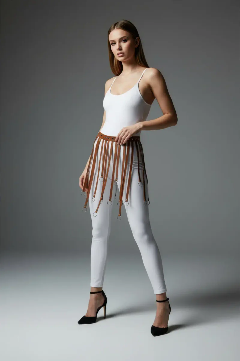 Model wearing tan faux leather waist harness over white outfit, back view