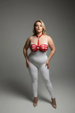 Red faux leather strappy chest harness with O-ring detail worn by a plus-size model