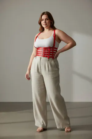 Red Faux Leather Multi-Strap Body Harness, worn over a white tank top with beige pants